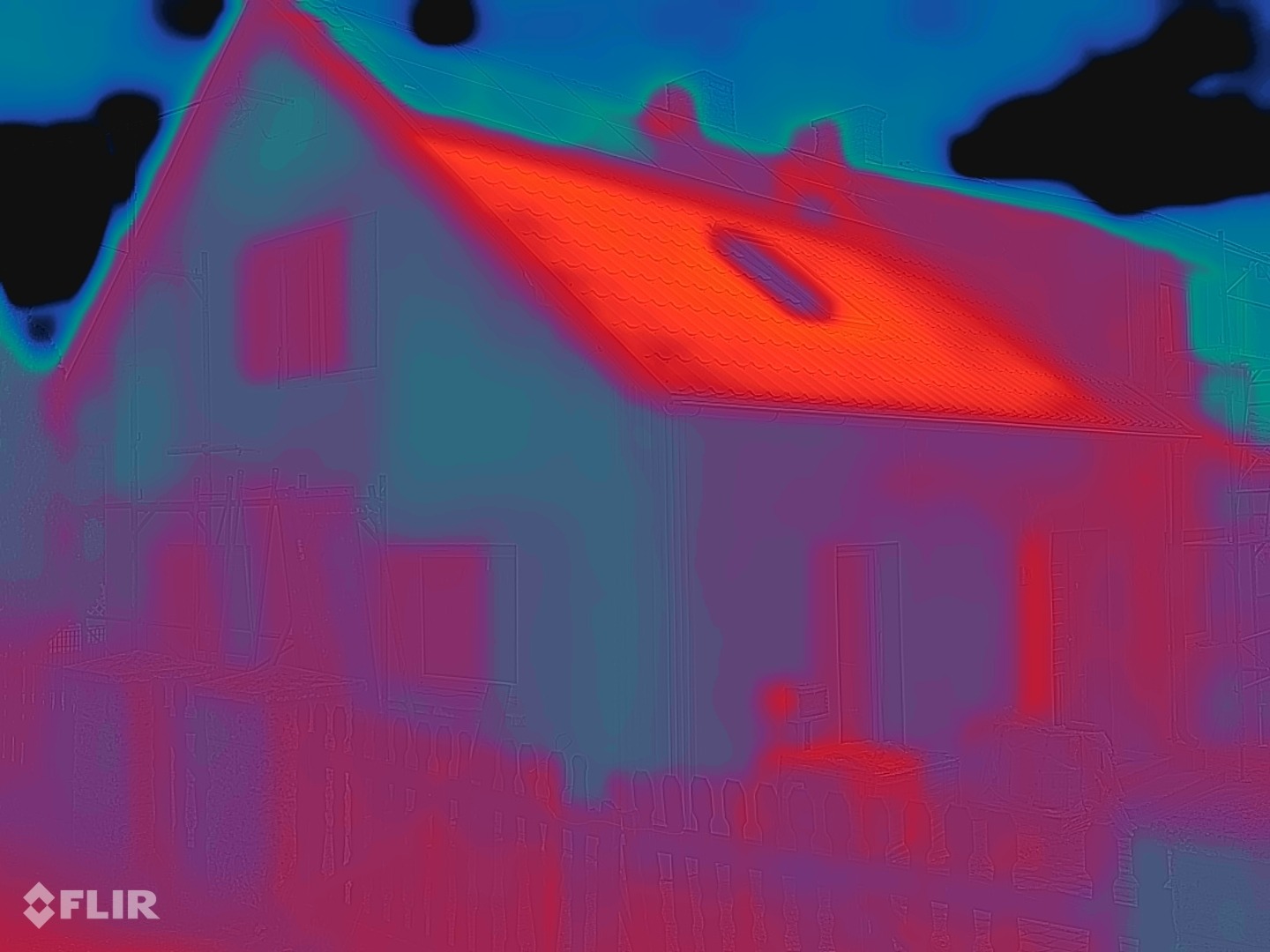 FLIR-warmtebeeld van dezelfde gevel na de coating: muuroppervlak blauwgroen tot violet